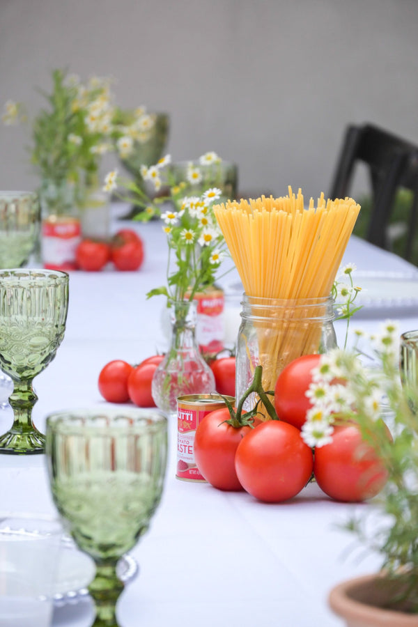 Patio table styled with tomatoes, daisies and spaghetti